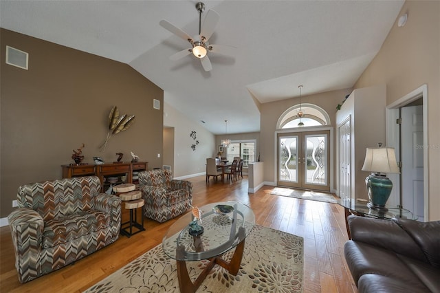 living room featuring vaulted ceiling, ceiling fan, light hardwood / wood-style flooring, and french doors