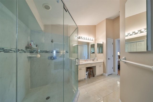 bathroom with tile patterned flooring, a shower with shower door, and vanity