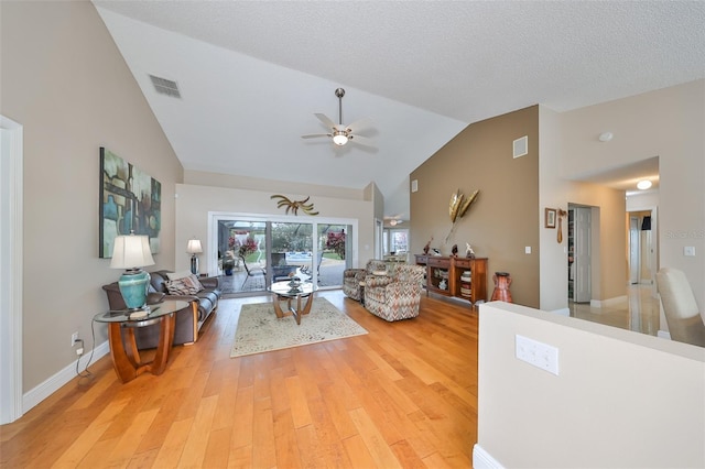 living room featuring a textured ceiling, ceiling fan, vaulted ceiling, and hardwood / wood-style flooring