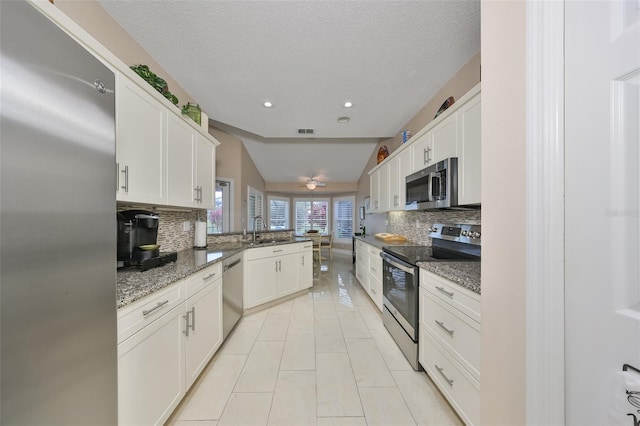 kitchen with white cabinetry, appliances with stainless steel finishes, and tasteful backsplash