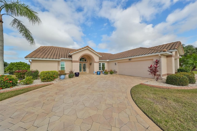 2337 Platinum Dr, Sun City Center, FL 33573 - mediterranean / spanish-style house featuring decorative driveway, an attached garage, french doors, and stucco siding