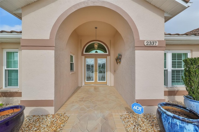 2337 Platinum Dr, Sun City Center, FL 33573 - view of exterior entry featuring french doors and stucco siding