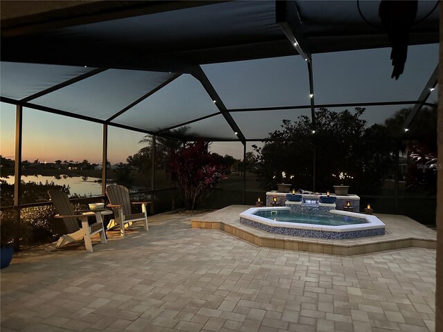 2337 Platinum Dr, Sun City Center, FL 33573 - pool at dusk featuring a patio, an in ground hot tub, a lanai, and a water view