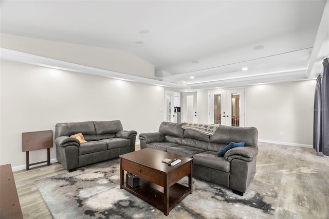 living room with hardwood / wood-style floors, vaulted ceiling, and french doors