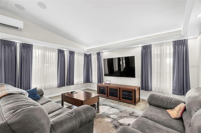 living room featuring a wall unit AC, vaulted ceiling, and light wood-type flooring