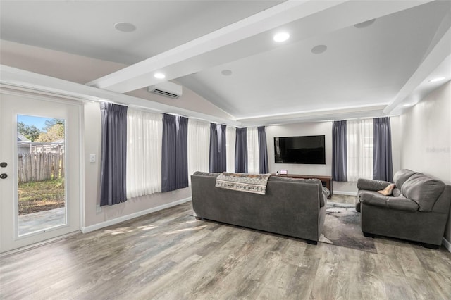 living room featuring hardwood / wood-style floors, a wall unit AC, and lofted ceiling