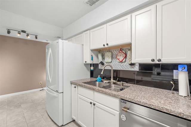 kitchen with stainless steel dishwasher, white refrigerator, white cabinetry, and sink