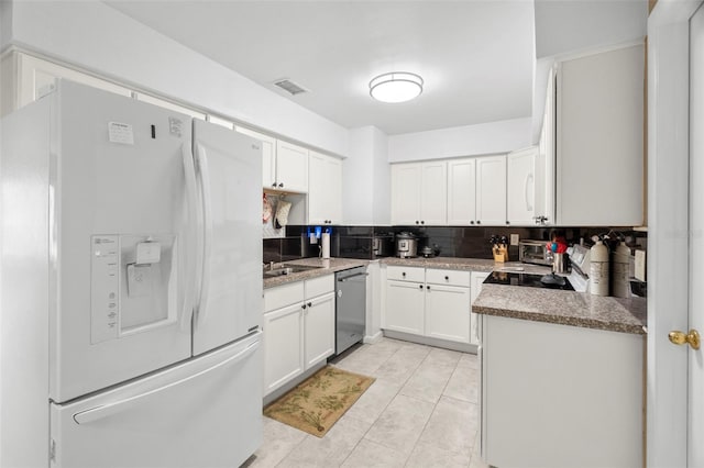 kitchen featuring dishwasher, white fridge with ice dispenser, white cabinets, and light stone countertops