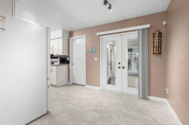 interior space with french doors and a textured ceiling