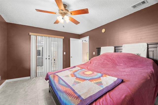 bedroom with ceiling fan, light tile patterned floors, a textured ceiling, and access to outside