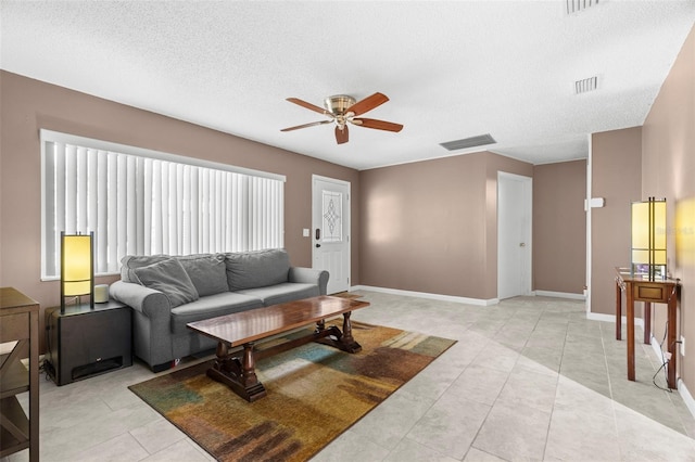 tiled living room with ceiling fan and a textured ceiling