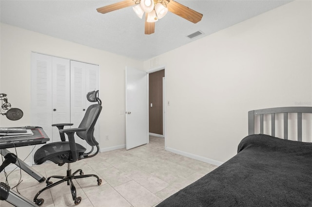 tiled bedroom with ceiling fan and a closet