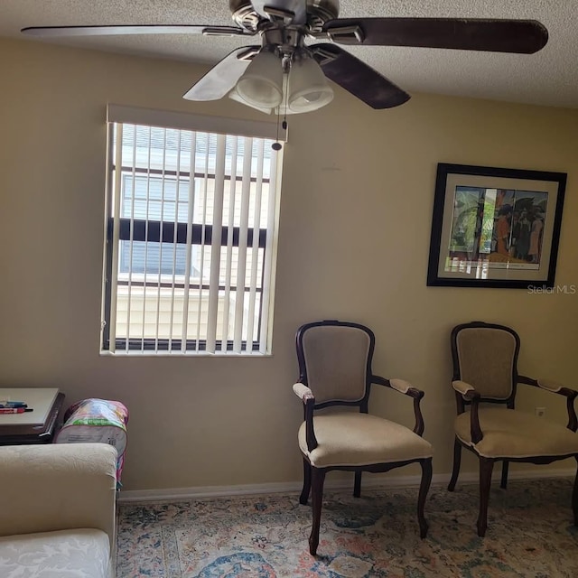 sitting room featuring a textured ceiling, a water view, plenty of natural light, and ceiling fan