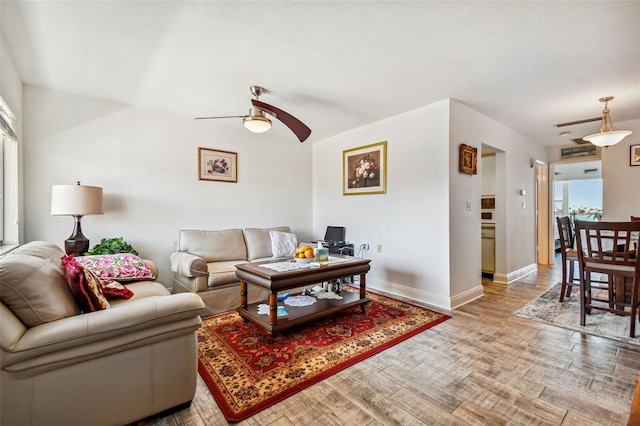 living room with ceiling fan and light wood-type flooring