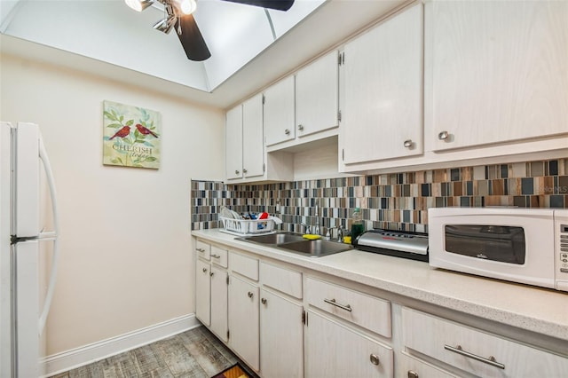 kitchen with ceiling fan, sink, tasteful backsplash, light hardwood / wood-style flooring, and white appliances