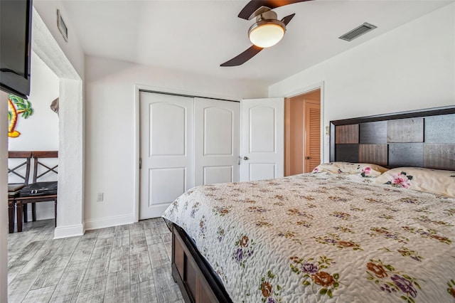 bedroom with a closet, light hardwood / wood-style flooring, and ceiling fan