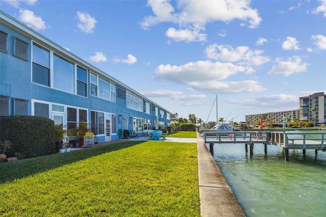 dock area featuring a lawn and a water view