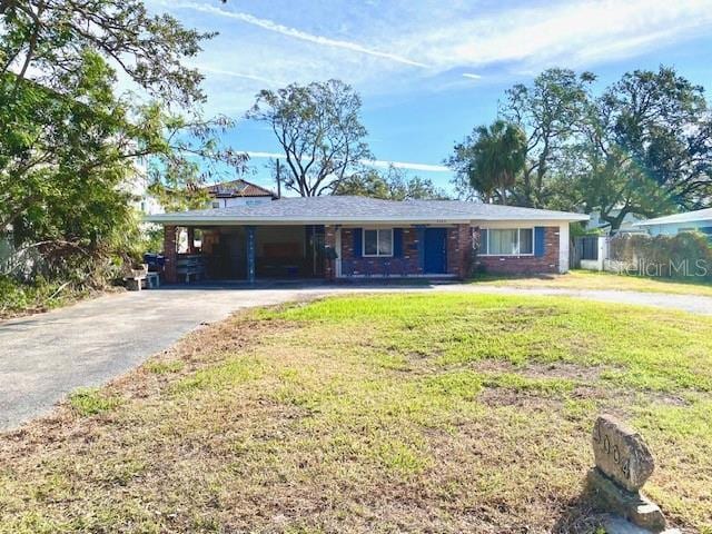 ranch-style home with a front yard and a carport