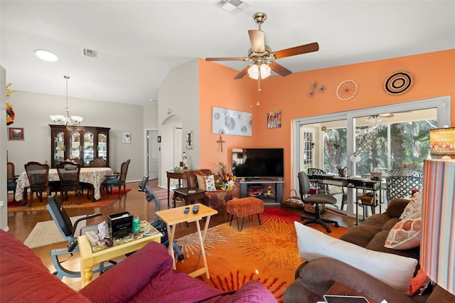 living room with vaulted ceiling, hardwood / wood-style floors, and ceiling fan with notable chandelier