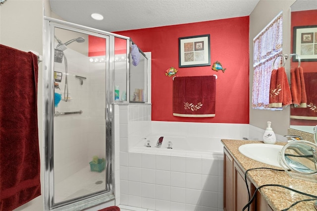 bathroom with vanity, a textured ceiling, and shower with separate bathtub