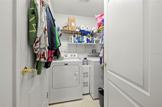 laundry area with washer and clothes dryer and a textured ceiling