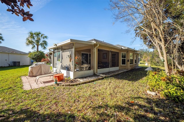 rear view of house with a sunroom, a patio area, a yard, and central air condition unit