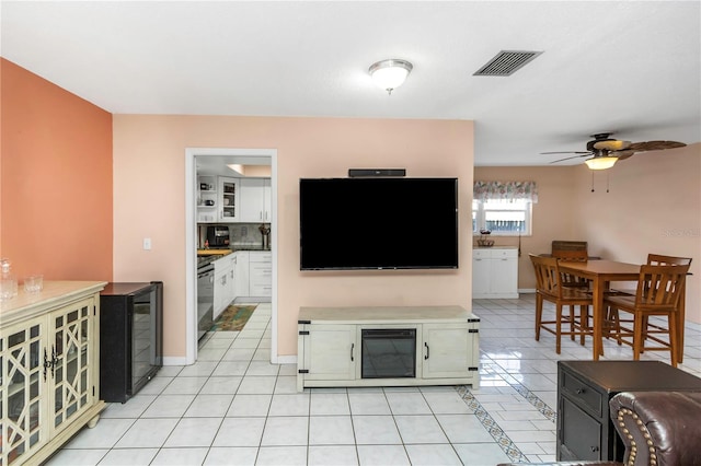 living room featuring light tile patterned floors, wine cooler, and ceiling fan