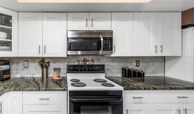 kitchen with backsplash, white cabinetry, dark stone counters, and electric stove