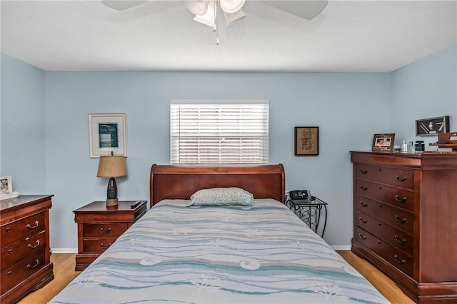 bedroom with ceiling fan, light hardwood / wood-style flooring, and a textured ceiling