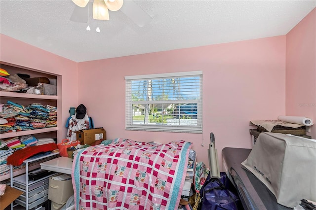 bedroom featuring ceiling fan and a textured ceiling