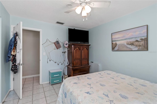 tiled bedroom featuring a textured ceiling and ceiling fan