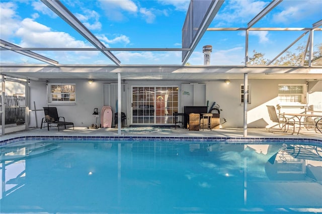 view of pool featuring glass enclosure and a patio