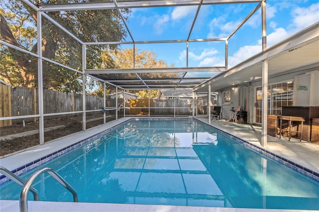 view of swimming pool with glass enclosure and a patio