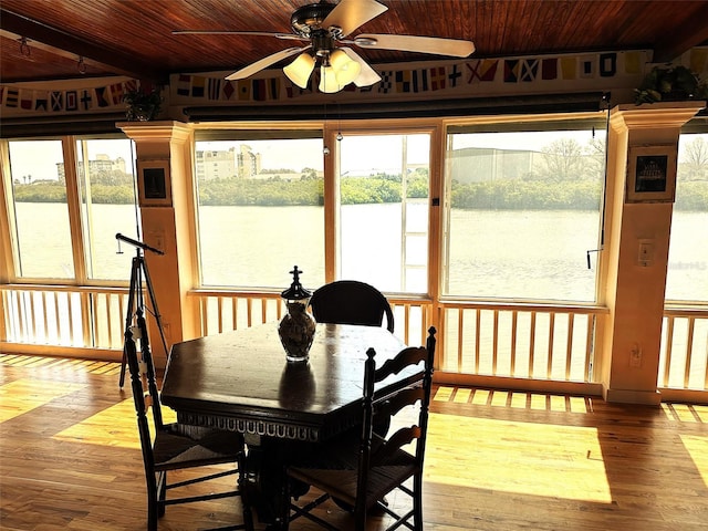 sunroom featuring ceiling fan, a water view, and wood ceiling