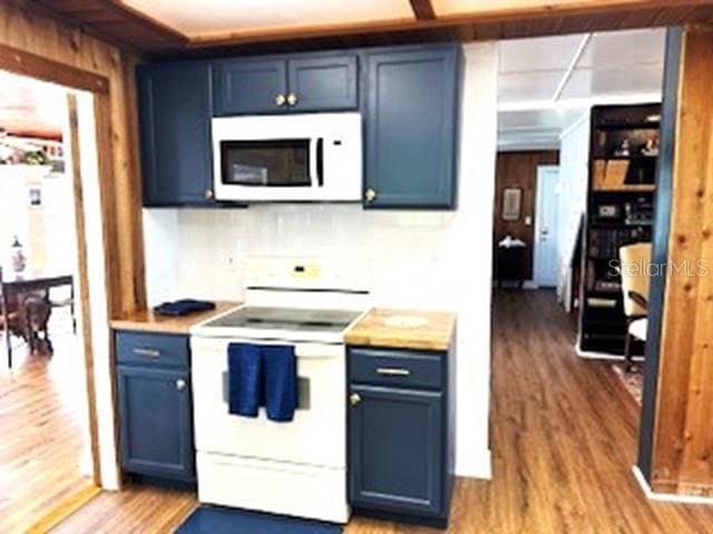 kitchen featuring blue cabinetry, hardwood / wood-style floors, and white appliances