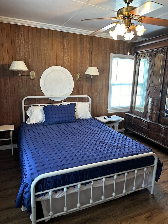 bedroom featuring dark hardwood / wood-style floors, ceiling fan, crown molding, and wood walls