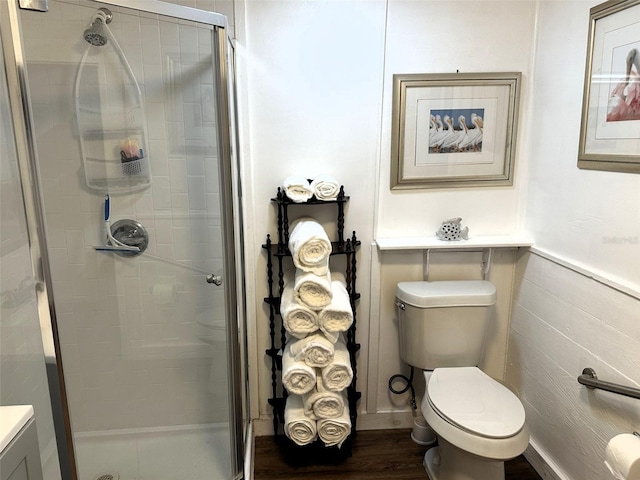 bathroom featuring an enclosed shower, toilet, and hardwood / wood-style flooring