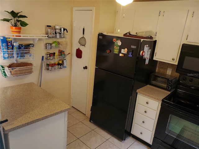 kitchen featuring tasteful backsplash, white cabinetry, light tile patterned floors, and black appliances