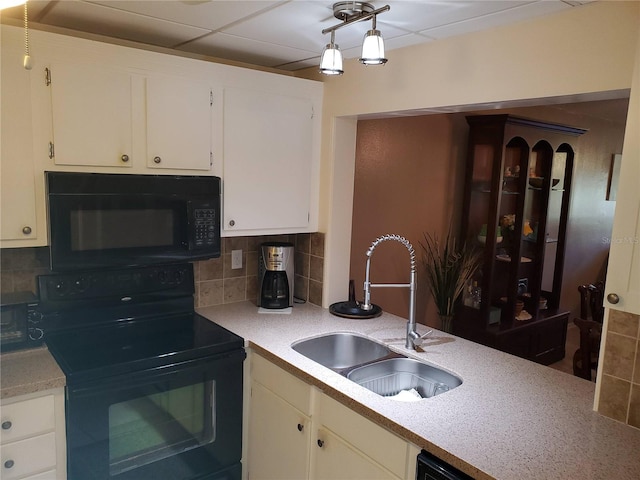 kitchen with a paneled ceiling, decorative backsplash, sink, and black appliances