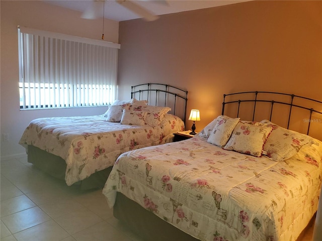 tiled bedroom featuring ceiling fan