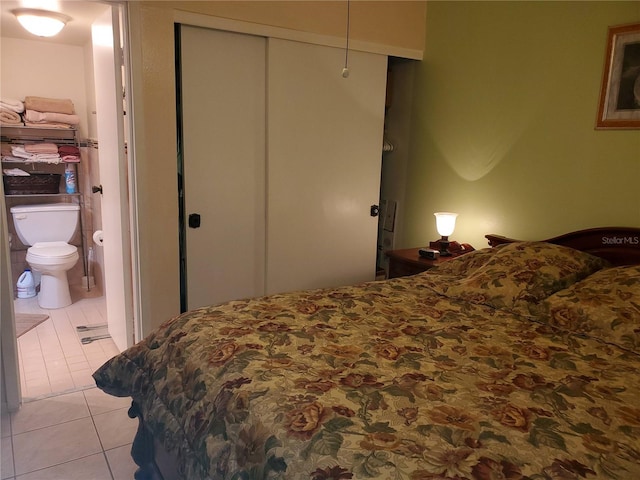 bedroom featuring connected bathroom, a closet, and light tile patterned flooring