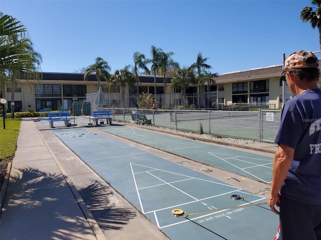 view of home's community featuring tennis court