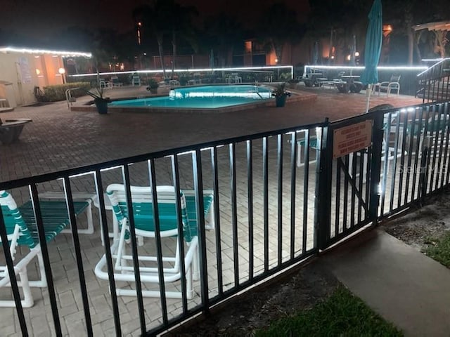 pool at twilight featuring a patio