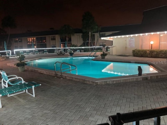 pool at twilight featuring a patio