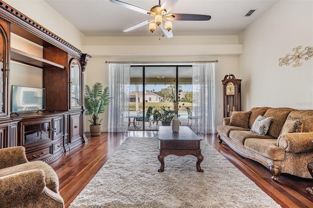 living room featuring ceiling fan and dark hardwood / wood-style flooring