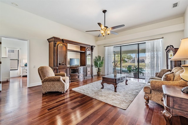 living room featuring ceiling fan and dark wood-type flooring