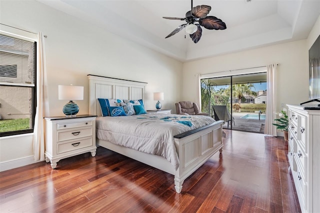 bedroom featuring access to exterior, a tray ceiling, ceiling fan, and dark wood-type flooring