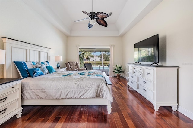 bedroom with access to outside, a raised ceiling, ceiling fan, and dark wood-type flooring