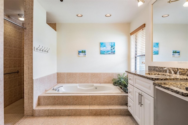 bathroom with plus walk in shower, tile patterned flooring, and vanity