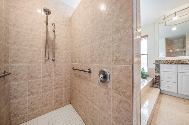 bathroom featuring a tile shower and vanity